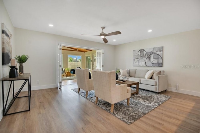 living room featuring french doors, ceiling fan, and light hardwood / wood-style flooring