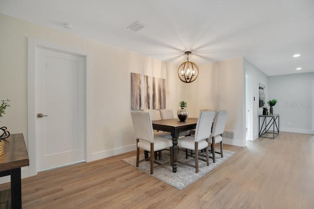 dining space with light wood-type flooring and a chandelier