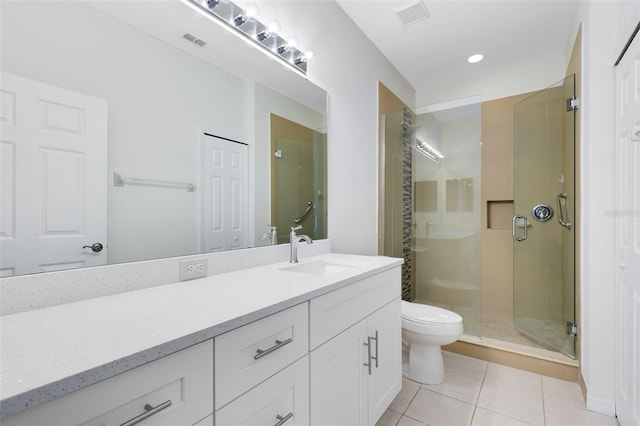 bathroom featuring walk in shower, vanity, tile patterned flooring, and toilet