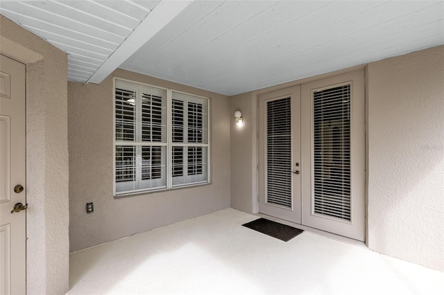 view of exterior entry featuring french doors and a patio