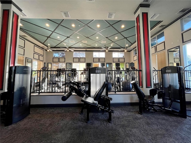 exercise room featuring carpet floors and a high ceiling