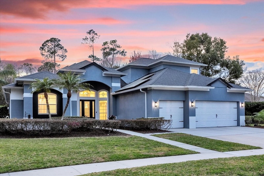 view of front facade with a garage and a yard