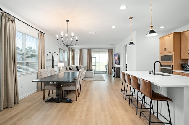 dining space with a wealth of natural light, sink, and light hardwood / wood-style floors