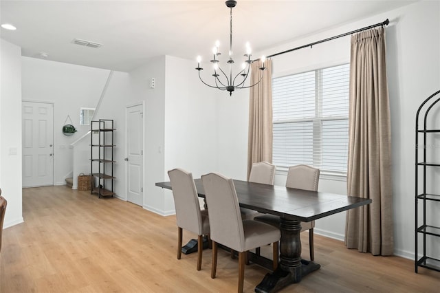 dining area featuring light hardwood / wood-style flooring and an inviting chandelier