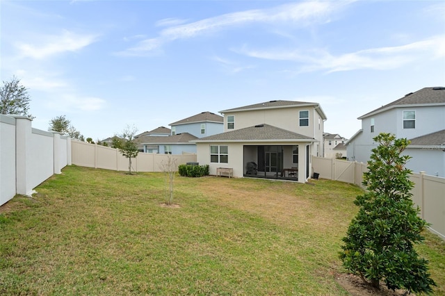 rear view of property featuring a yard and a sunroom