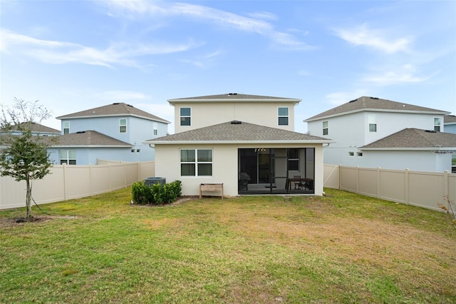 rear view of property with a sunroom and a yard