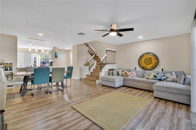 living room with light wood-type flooring and ceiling fan