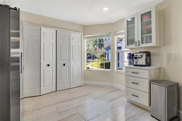 kitchen featuring stainless steel fridge and white cabinetry