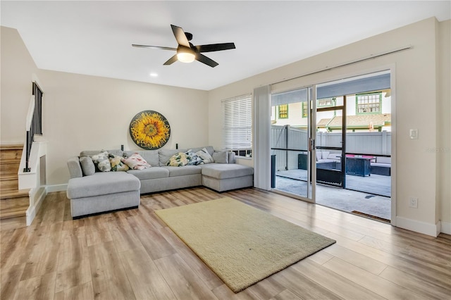 living room with ceiling fan and light hardwood / wood-style flooring