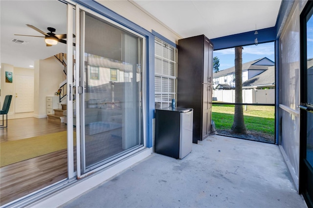 unfurnished sunroom with ceiling fan