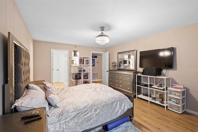 bedroom with light wood finished floors, visible vents, and baseboards