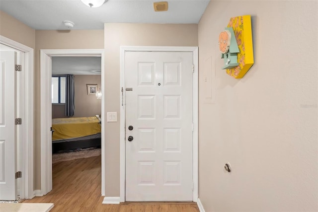 hall featuring baseboards and light wood finished floors