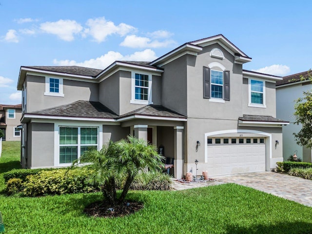 view of property featuring a front yard and a garage