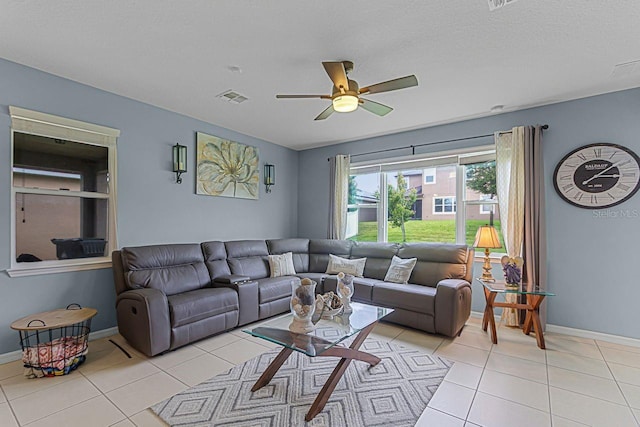 tiled living room featuring ceiling fan and a textured ceiling