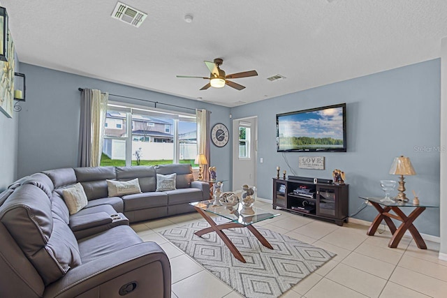 tiled living room with a textured ceiling and ceiling fan