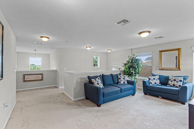 carpeted living room with plenty of natural light and a textured ceiling