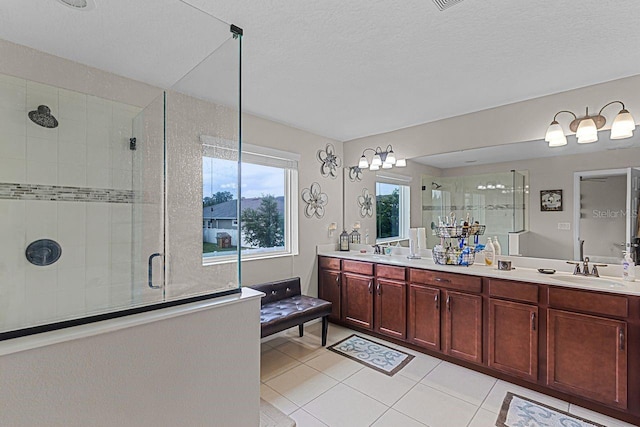 bathroom featuring an enclosed shower, vanity, tile patterned flooring, and a textured ceiling