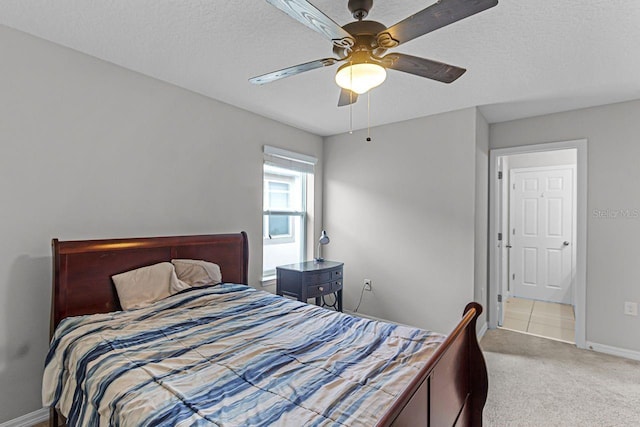 carpeted bedroom with ceiling fan and a textured ceiling