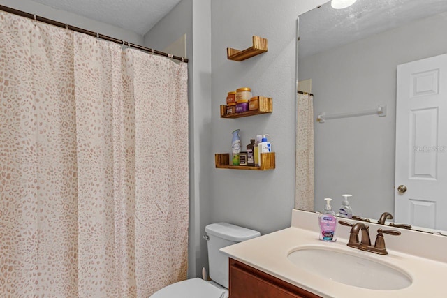 bathroom featuring vanity, toilet, and a textured ceiling