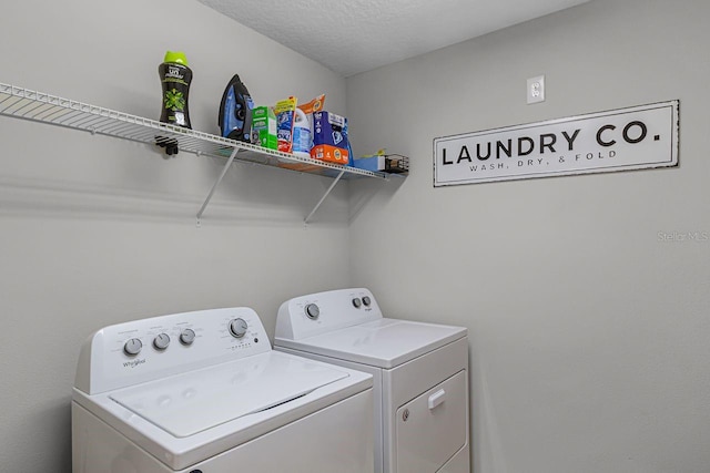 washroom with a textured ceiling and independent washer and dryer