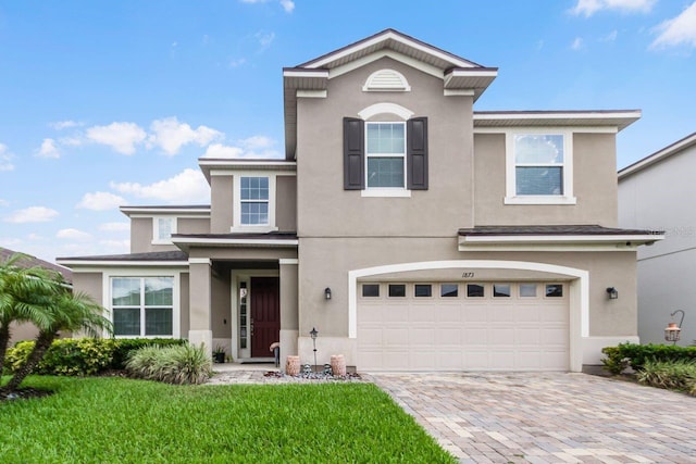 view of front of property with a garage and a front lawn