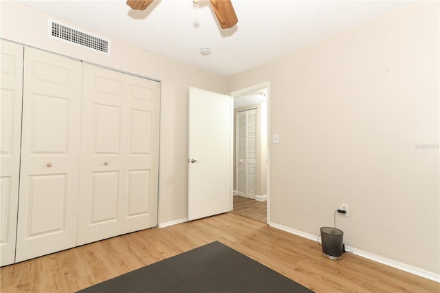 workout area featuring ceiling fan, a textured ceiling, and wood-type flooring