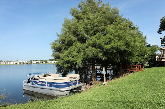 dock area with a lawn and a water view