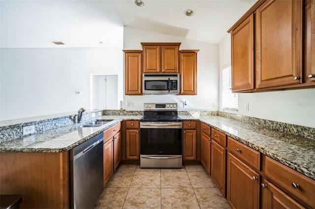 kitchen with appliances with stainless steel finishes, light stone countertops, light tile patterned floors, sink, and lofted ceiling