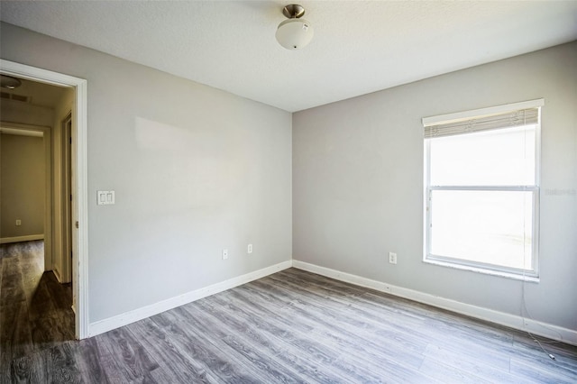 unfurnished room with a healthy amount of sunlight and wood-type flooring