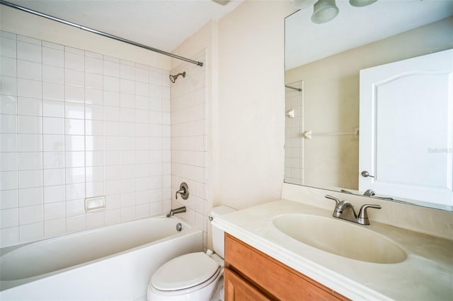 full bathroom featuring vanity, tiled shower / bath combo, and toilet