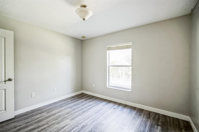 unfurnished room with a textured ceiling and hardwood / wood-style floors