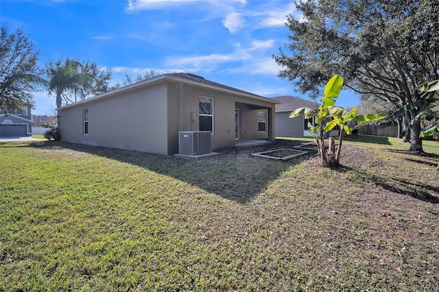 rear view of house with cooling unit and a yard