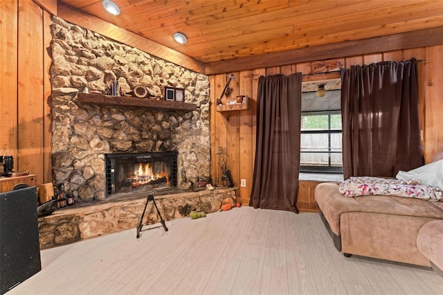 living room featuring a fireplace, wooden ceiling, and wooden walls