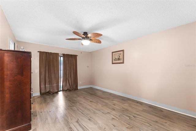 unfurnished bedroom with ceiling fan, a textured ceiling, and light wood-type flooring