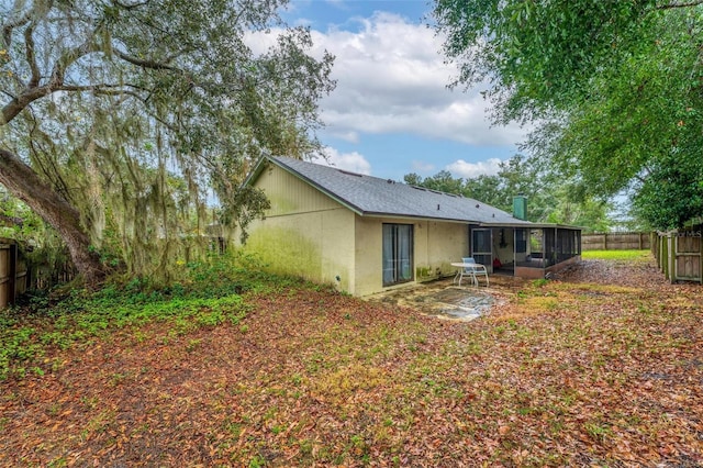 back of property with a patio area and a sunroom