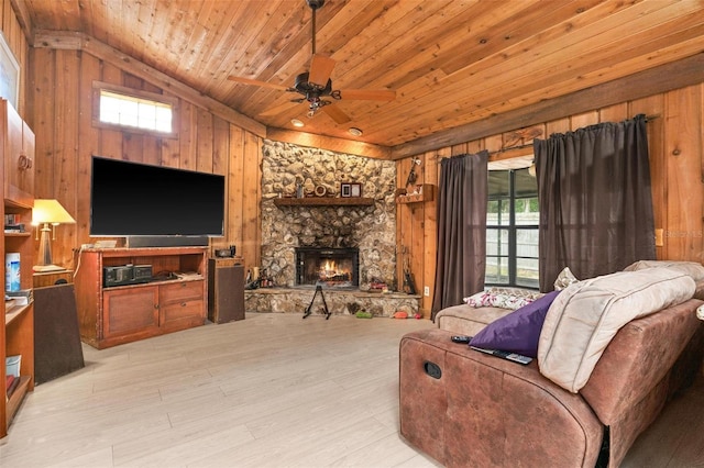 living room featuring lofted ceiling, a fireplace, light wood-type flooring, ceiling fan, and wooden ceiling