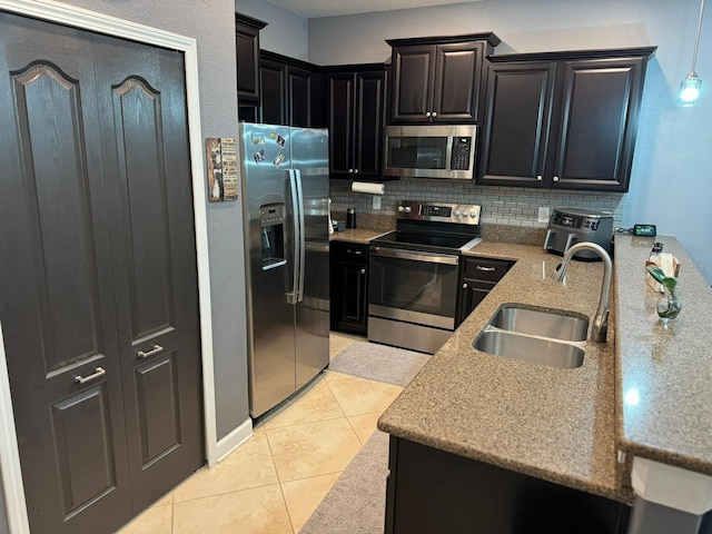 kitchen featuring light tile patterned floors, sink, decorative backsplash, and appliances with stainless steel finishes