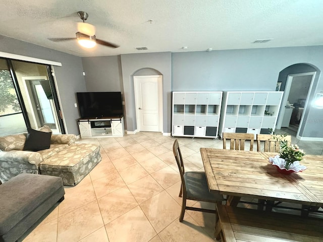 tiled dining room featuring ceiling fan and a textured ceiling