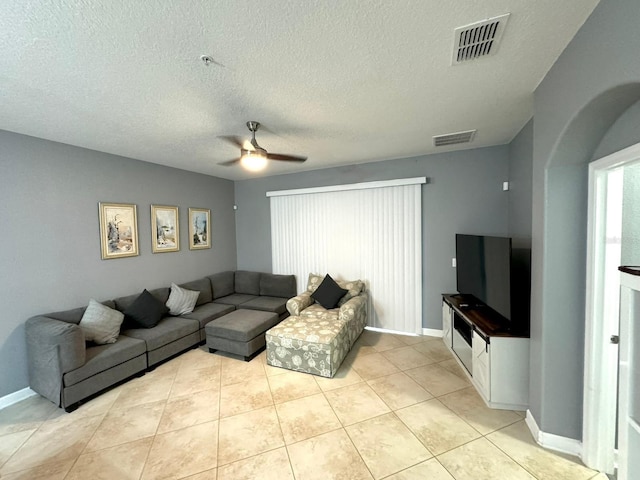 living room with ceiling fan, a textured ceiling, and light tile patterned flooring