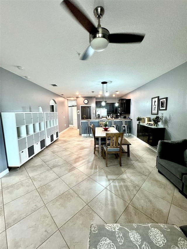 dining area with ceiling fan and a textured ceiling