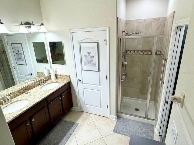 bathroom featuring tile patterned flooring, a shower with shower door, and vanity