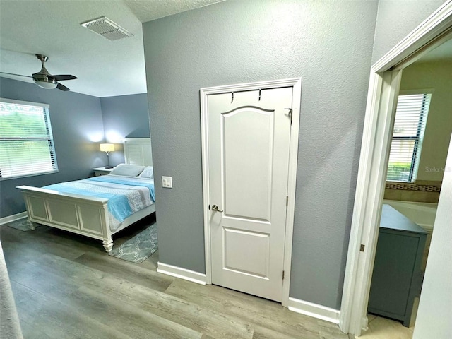 bedroom featuring a textured ceiling, ceiling fan, and light hardwood / wood-style floors