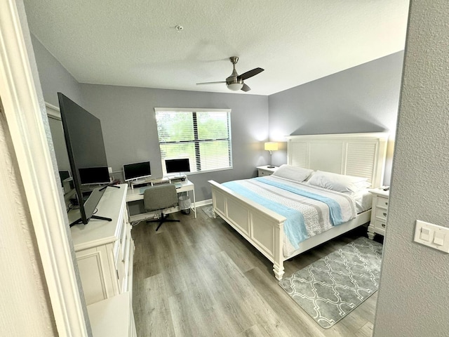 bedroom featuring ceiling fan, a textured ceiling, and light wood-type flooring