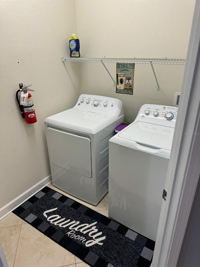 laundry room with washer and clothes dryer and light tile patterned floors