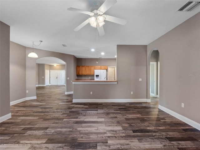 unfurnished living room featuring ceiling fan and dark hardwood / wood-style flooring