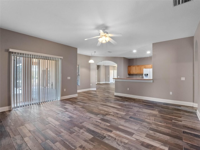 unfurnished living room featuring ceiling fan and dark hardwood / wood-style floors