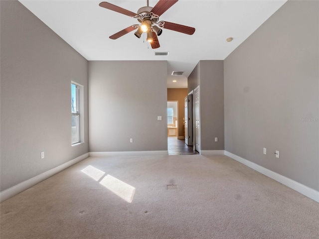 carpeted spare room featuring ceiling fan