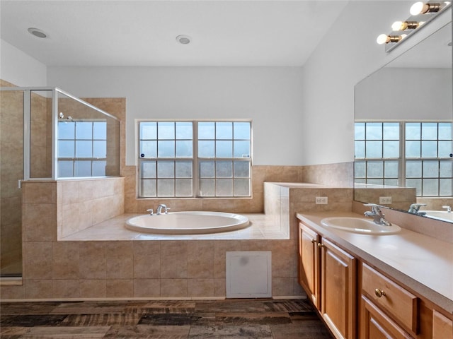 bathroom featuring shower with separate bathtub, vanity, and a healthy amount of sunlight