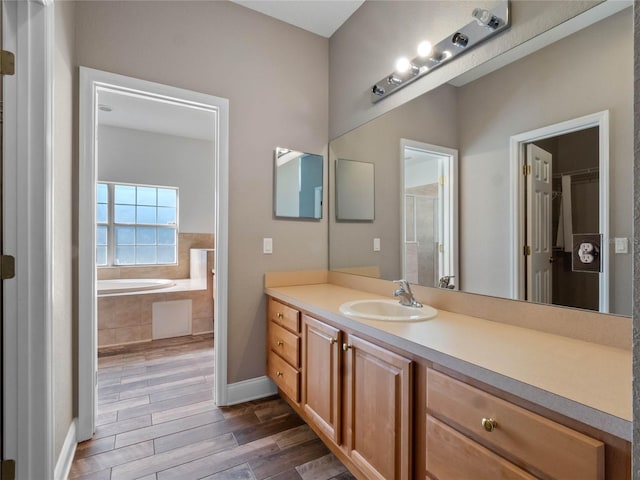 bathroom featuring tiled bath and vanity