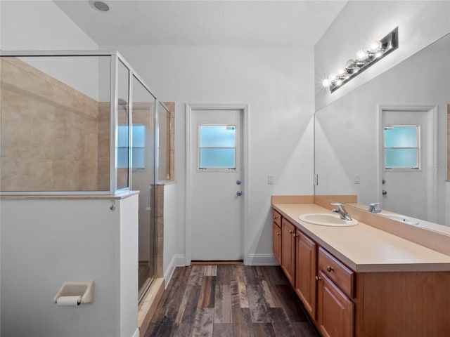 bathroom with vanity, a shower with shower door, a wealth of natural light, and hardwood / wood-style floors